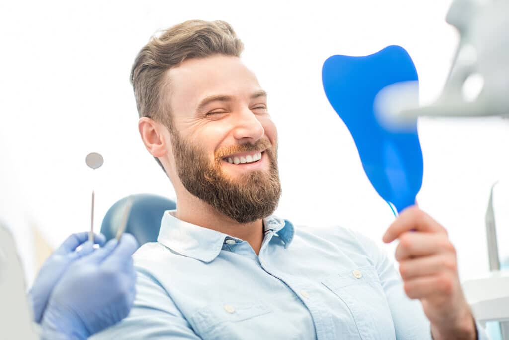 man.smiling.dental.chair